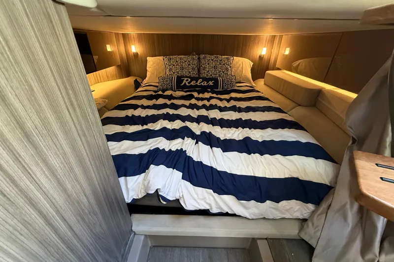  Yacht Photos Pics Luxurious cabin interior of 2022 Sea Ray SLX 400 with cozy bed and ambient lighting.