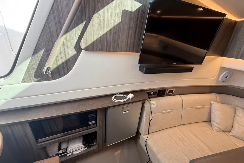  Yacht Photos Pics Interior of 2022 Sea Ray SLX 400 yacht with TV, seating, and kitchenette.