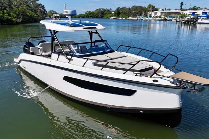  Yacht Photos Pics Navan S30 2026 boat cruising on a serene lake with lush greenery.