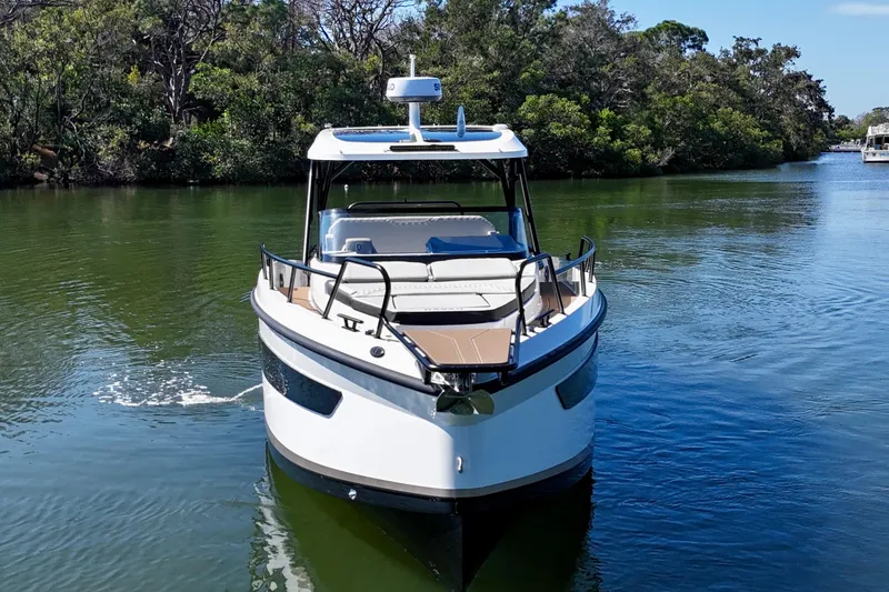  Yacht Photos Pics Navan S30 2026 boat cruising on a serene river surrounded by lush greenery.
