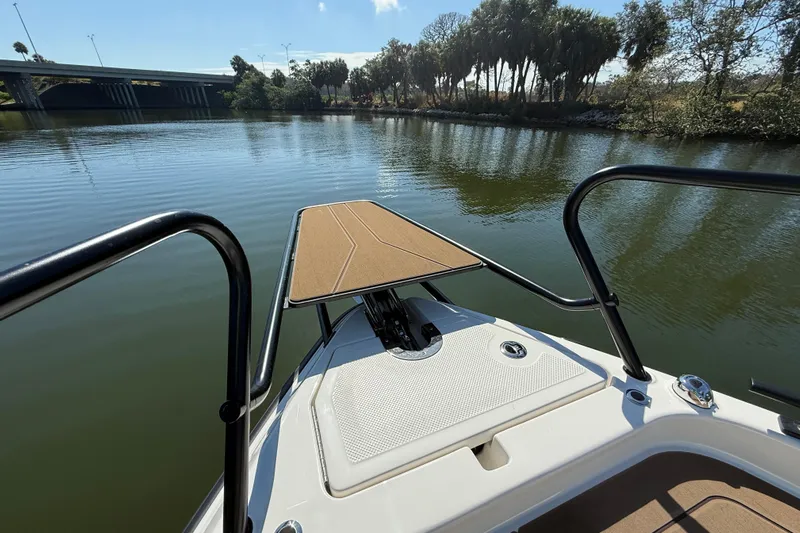  Yacht Photos Pics Bow view of 2026 Navan S30 boat on a calm river with trees and bridge.