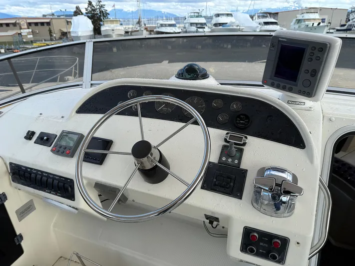  Yacht Photos Pics 2003 Meridian 490 Pilothouse helm with steering wheel and navigation equipment.