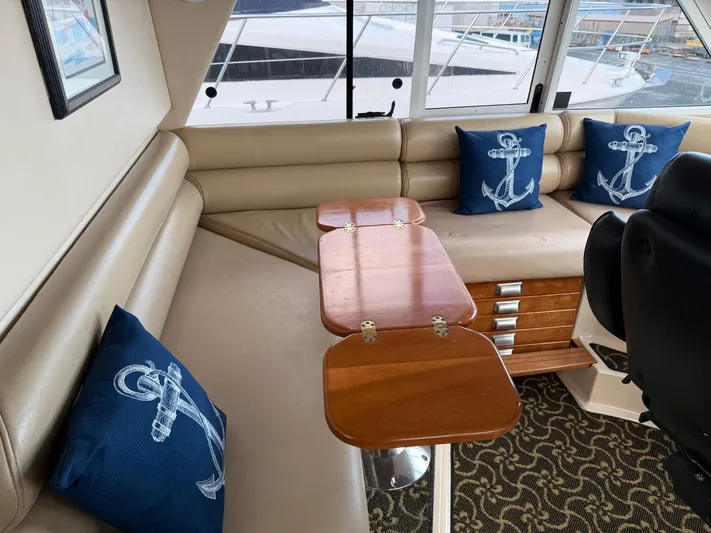  Yacht Photos Pics Luxurious 2003 Meridian 490 Pilothouse interior with nautical-themed cushions and elegant wood table.