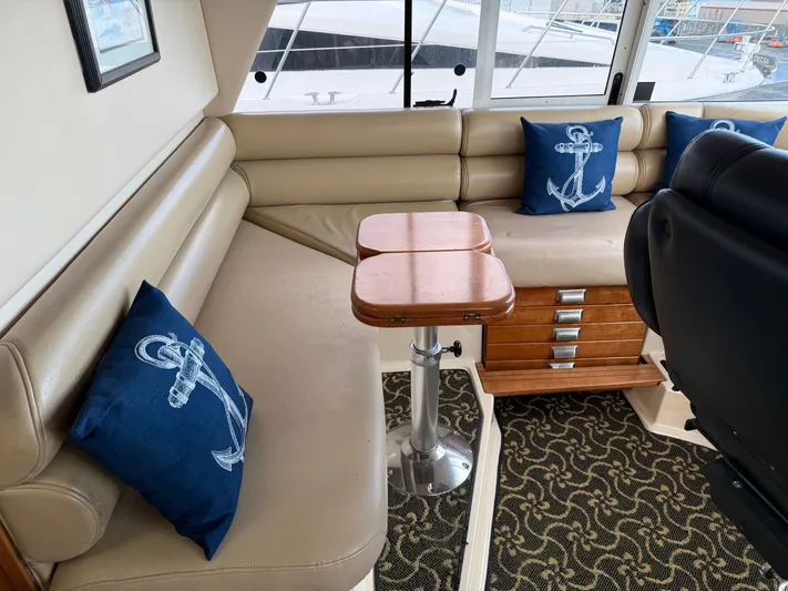  Yacht Photos Pics Interior of 2003 Meridian 490 Pilothouse with beige seating and nautical-themed pillows.