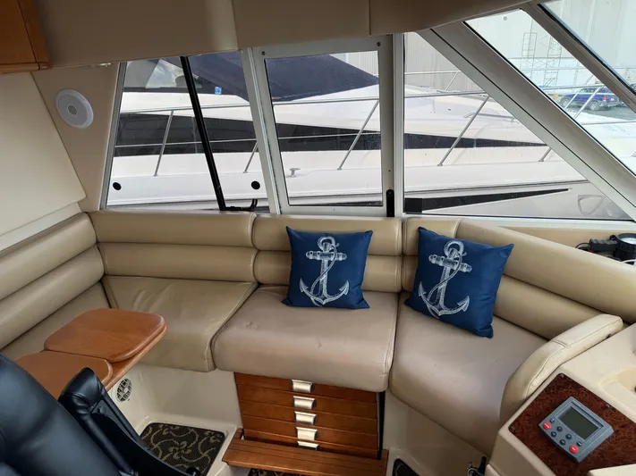 Yacht Photos Pics Interior of 2003 Meridian 490 Pilothouse with beige seating and nautical-themed cushions.
