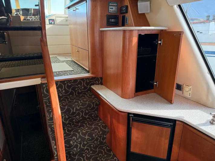  Yacht Photos Pics Interior of 2003 Meridian 490 Pilothouse with wood cabinetry and carpeted stairs.