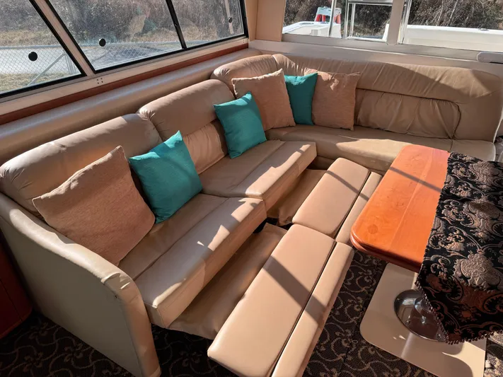  Yacht Photos Pics Luxurious interior of 2003 Meridian 490 Pilothouse with beige leather seating and turquoise cushions.