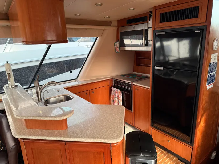  Yacht Photos Pics Interior of 2003 Meridian 490 Pilothouse yacht kitchen with wood cabinetry and modern appliances.