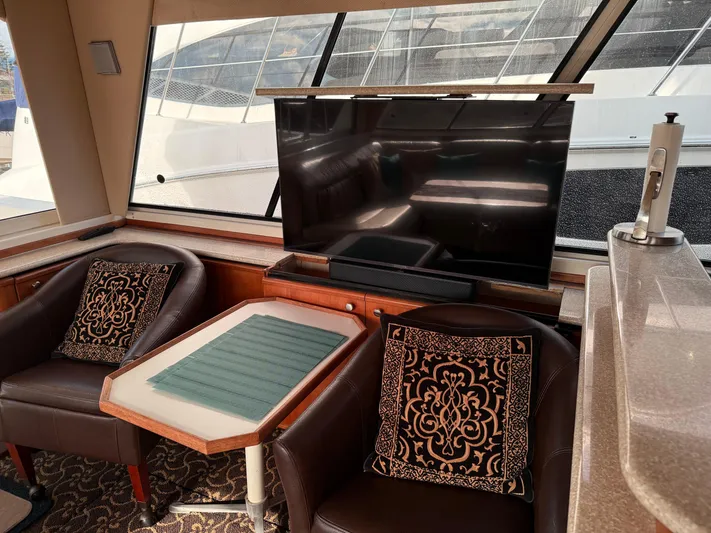  Yacht Photos Pics Interior of 2003 Meridian 490 Pilothouse with TV, chairs, and decorative pillows.