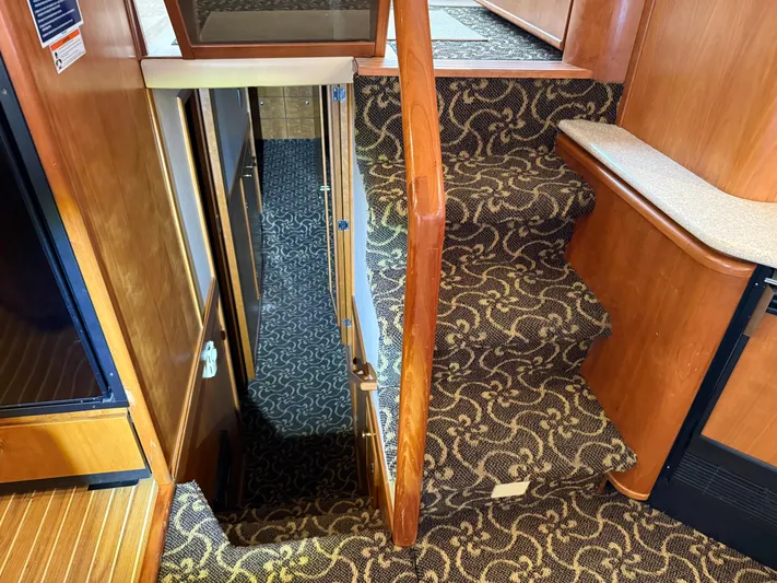  Yacht Photos Pics Interior stairs of 2003 Meridian 490 Pilothouse with patterned carpet and wooden finish.