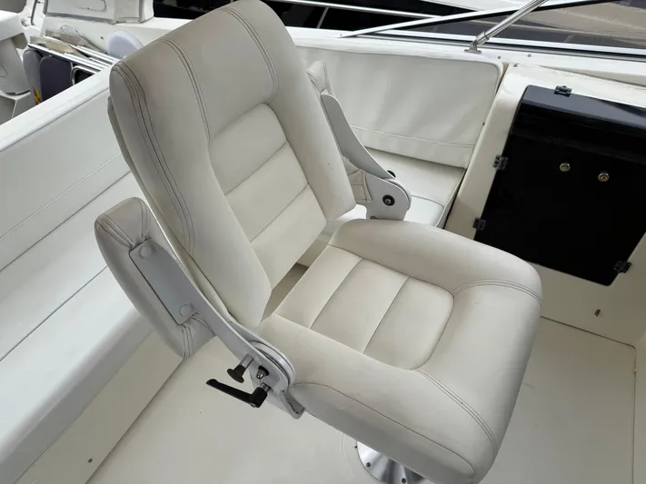  Yacht Photos Pics Captain's chair on 2003 Meridian 490 Pilothouse yacht, featuring white upholstery.