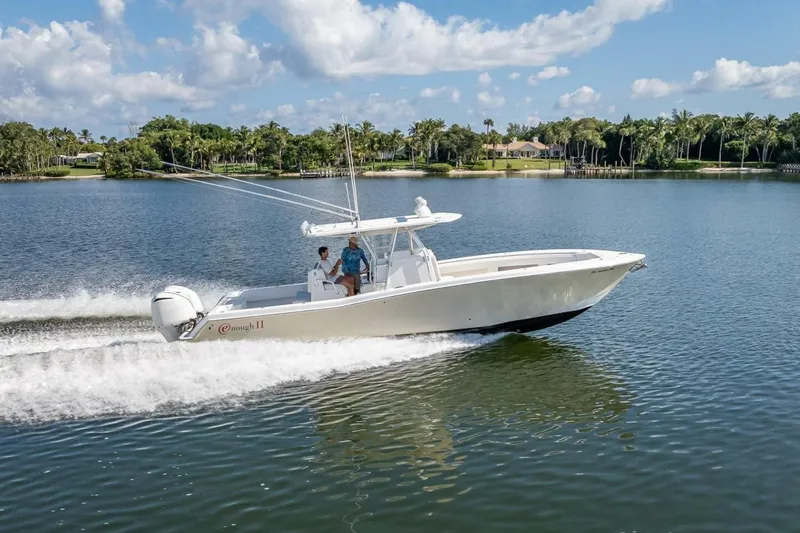  Yacht Photos Pics 2013 Invincible 36 boat cruising on a scenic lake under a clear blue sky.