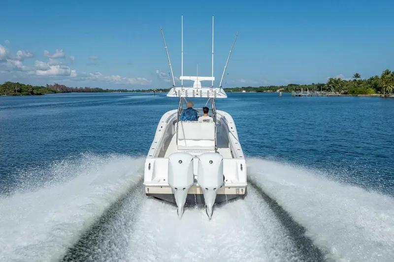  Yacht Photos Pics 2013 Invincible 36 boat cruising on a clear blue waterway under a sunny sky.