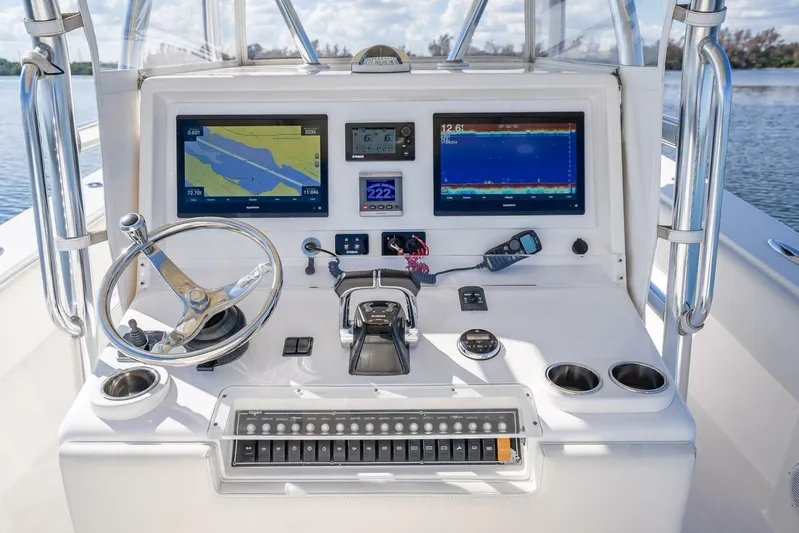 Yacht Photos Pics Control panel of a 2013 Invincible 36 boat with navigation screens and steering wheel.