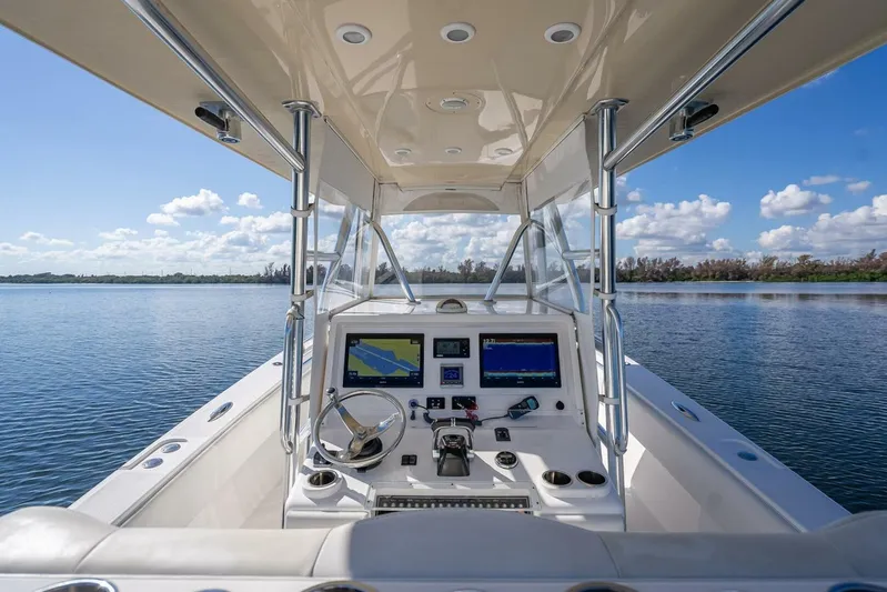  Yacht Photos Pics Cockpit view of 2013 Invincible 36 boat with navigation screens on a calm lake.