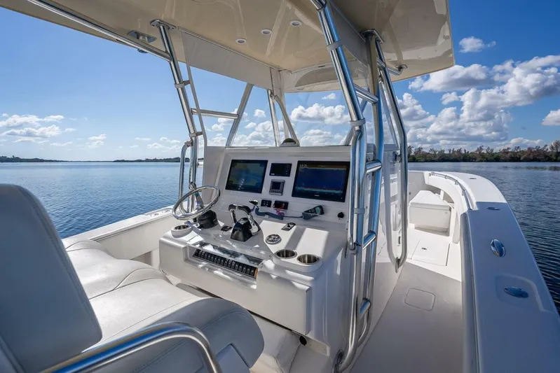  Yacht Photos Pics 2013 Invincible 36 boat interior with modern controls, steering wheel, and seating on a sunny day.
