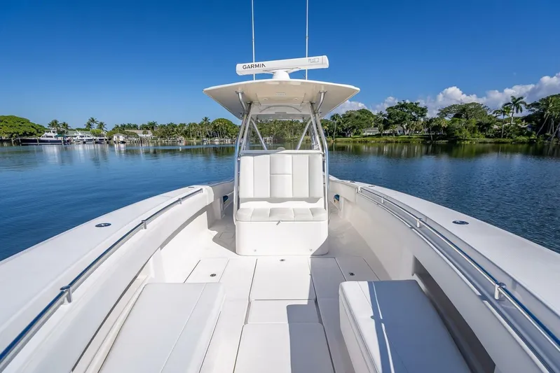  Yacht Photos Pics 2013 Invincible 36 boat on calm water, clear sky, and lush greenery.