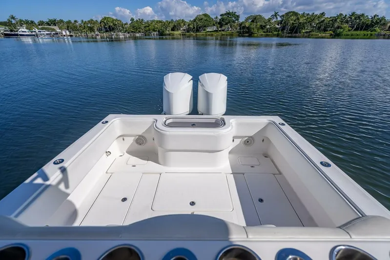  Yacht Photos Pics Invincible 36 boat deck, 2013 model, overlooking serene water and lush greenery.