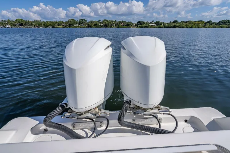  Yacht Photos Pics Twin outboard motors on a 2013 Invincible 36 boat, overlooking a serene lake.