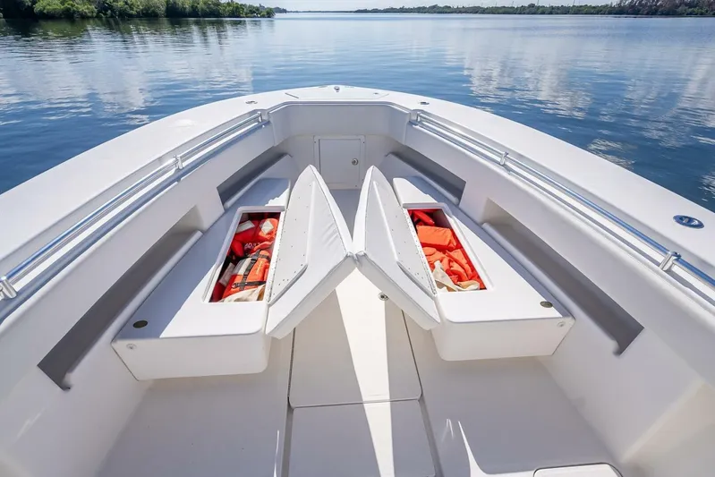  Yacht Photos Pics Bow of 2013 Invincible 36 boat with open storage compartments on calm water.