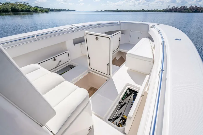  Yacht Photos Pics 2013 Invincible 36 boat interior with open storage compartments on a calm lake.