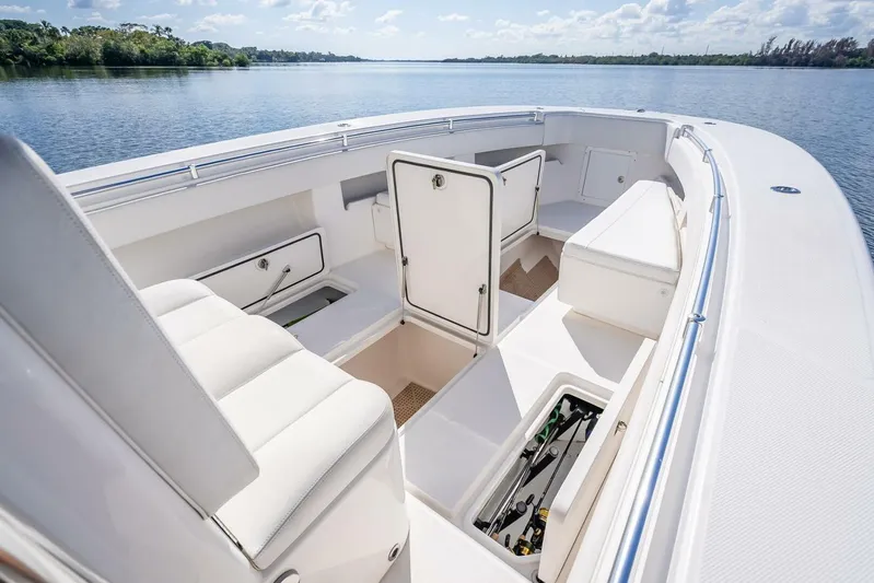  Yacht Photos Pics 2013 Invincible 36 boat interior with open storage compartments on a calm lake.