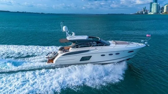 Presumed Innocent Yacht Photos Pics 2017 Princess V48 Open yacht cruising on blue ocean near city skyline.