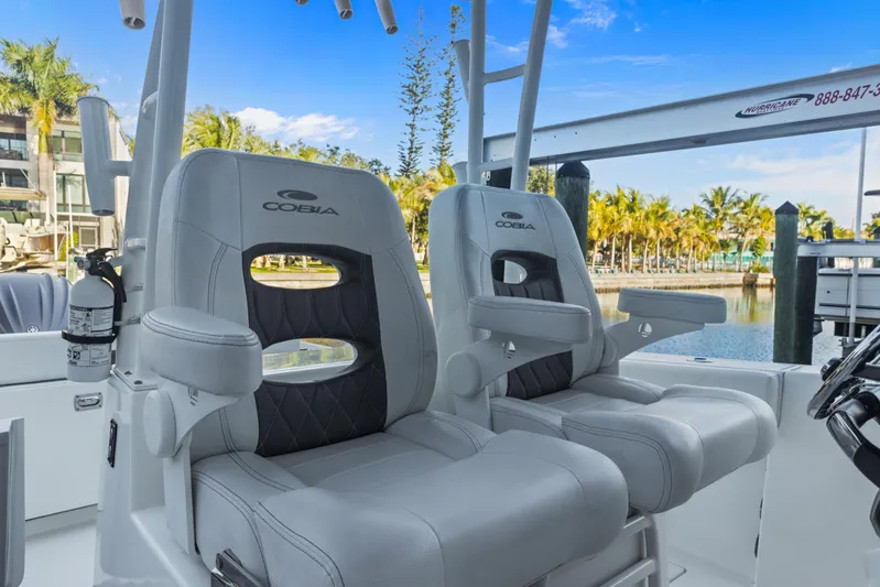  Yacht Photos Pics 2023 Cobia 301 Center Console boat seats with armrests, docked near palm trees.