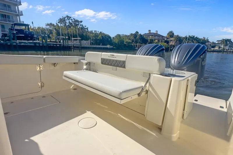  Yacht Photos Pics 2023 Cobia 301 Center Console boat with dual engines, docked by waterfront homes.