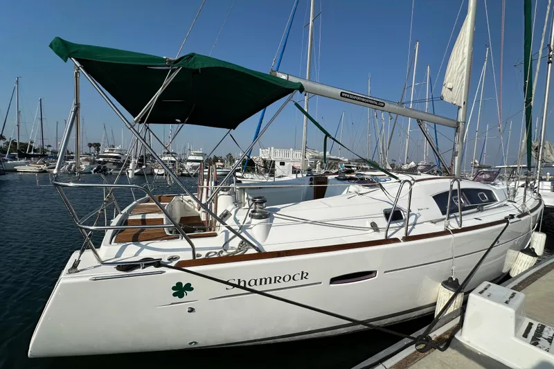 Shamrock Yacht Photos Pics 2011 Beneteau Oceanis 40 sailboat docked in marina, featuring green canopy and sleek design.
