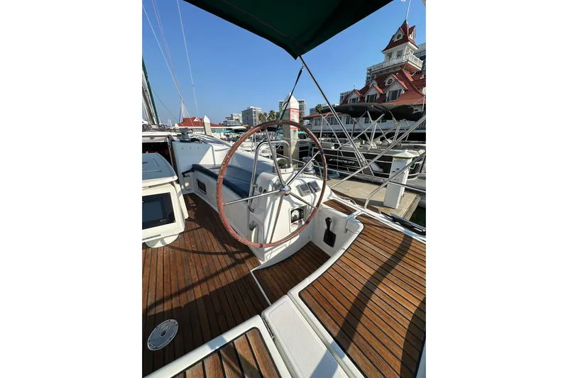 Shamrock Yacht Photos Pics 2011 Beneteau Oceanis 40 sailboat cockpit with wooden deck and steering wheel at marina.