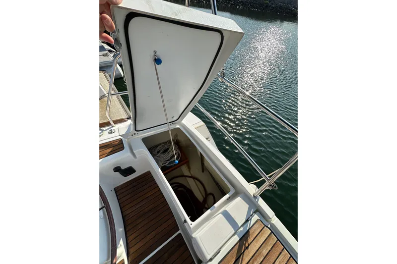 Shamrock Yacht Photos Pics Open storage compartment on 2011 Beneteau Oceanis 40 sailboat, docked by shimmering water.