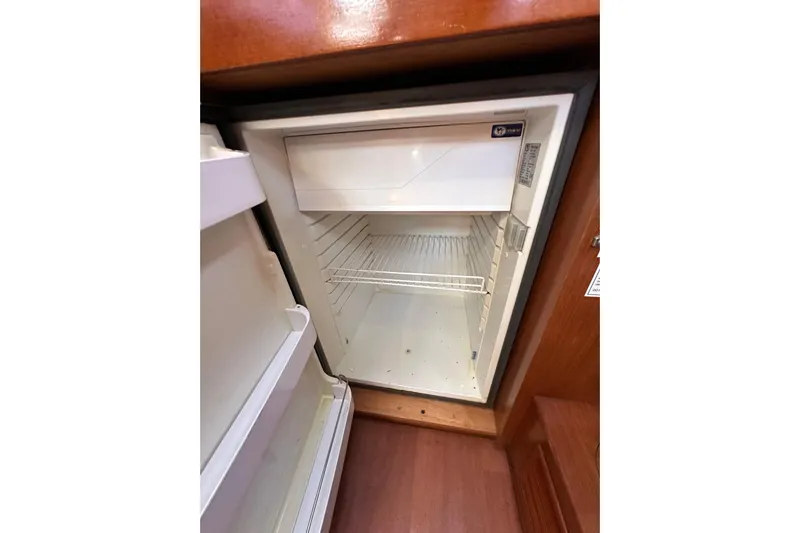 Shamrock Yacht Photos Pics Empty refrigerator inside 2011 Beneteau Oceanis 40 yacht, showcasing storage space.