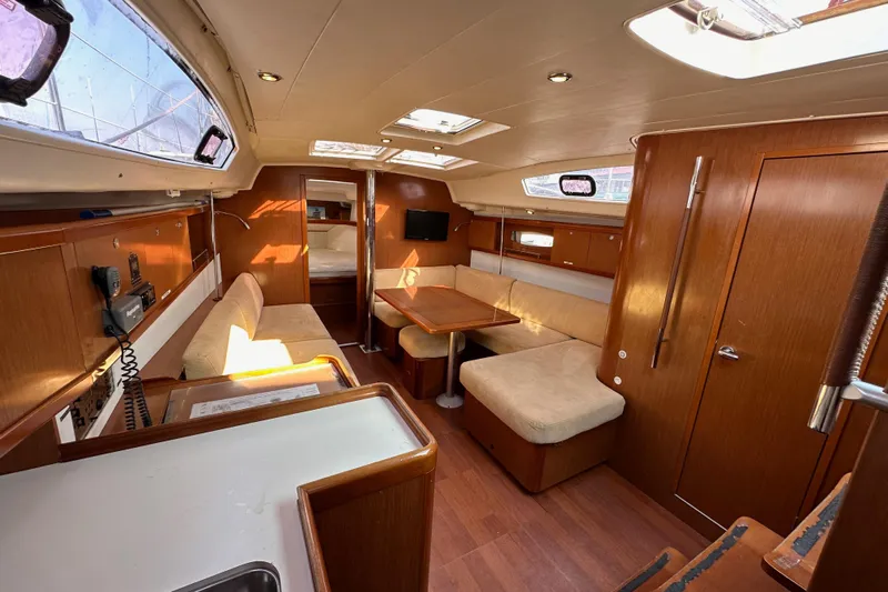 Shamrock Yacht Photos Pics Interior of 2011 Beneteau Oceanis 40 sailboat with cozy seating and wooden finishes.