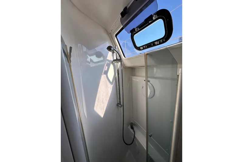 Shamrock Yacht Photos Pics Shower area inside a 2011 Beneteau Oceanis 40 yacht, featuring a window and modern fixtures.