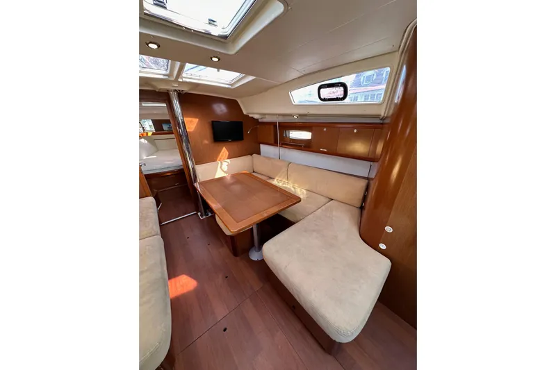 Shamrock Yacht Photos Pics Interior of 2011 Beneteau Oceanis 40 sailboat with cozy seating and wooden finishes.