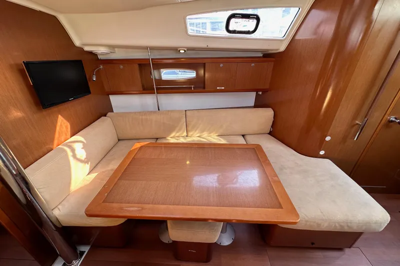 Shamrock Yacht Photos Pics Interior of 2011 Beneteau Oceanis 40 yacht with cozy seating and wooden table.
