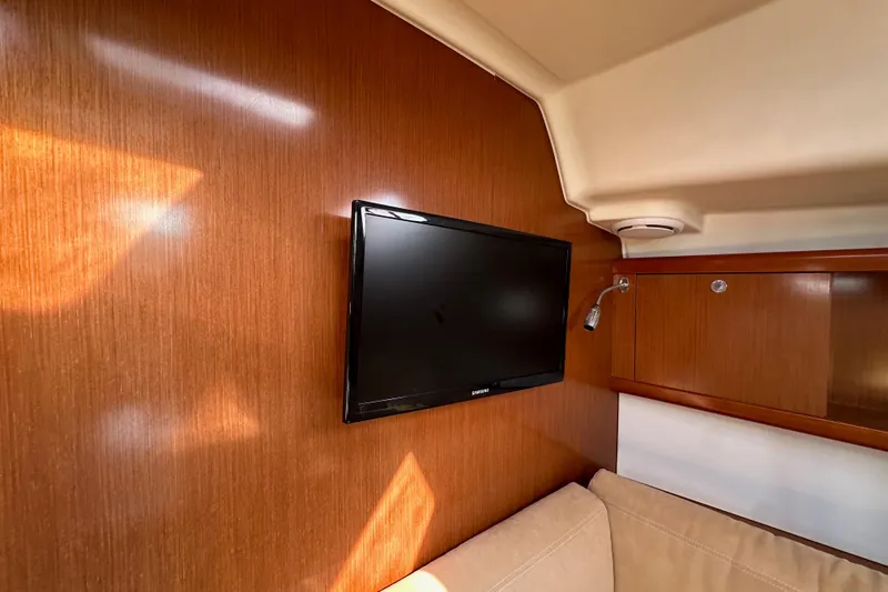 Shamrock Yacht Photos Pics Interior of 2011 Beneteau Oceanis 40 yacht with wall-mounted TV and wooden paneling.