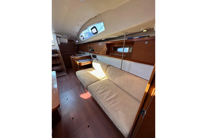 Shamrock Yacht Photos Pics Interior of 2011 Beneteau Oceanis 40 yacht with beige seating and wooden cabinetry.