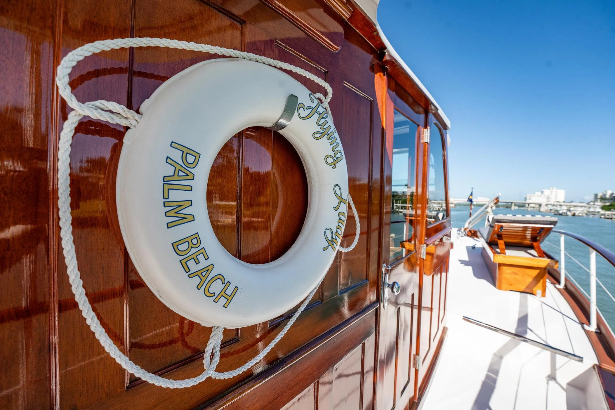 Vintage 1937 Trumpy yacht with lifebuoy, docked in sunny Palm Beach marina.