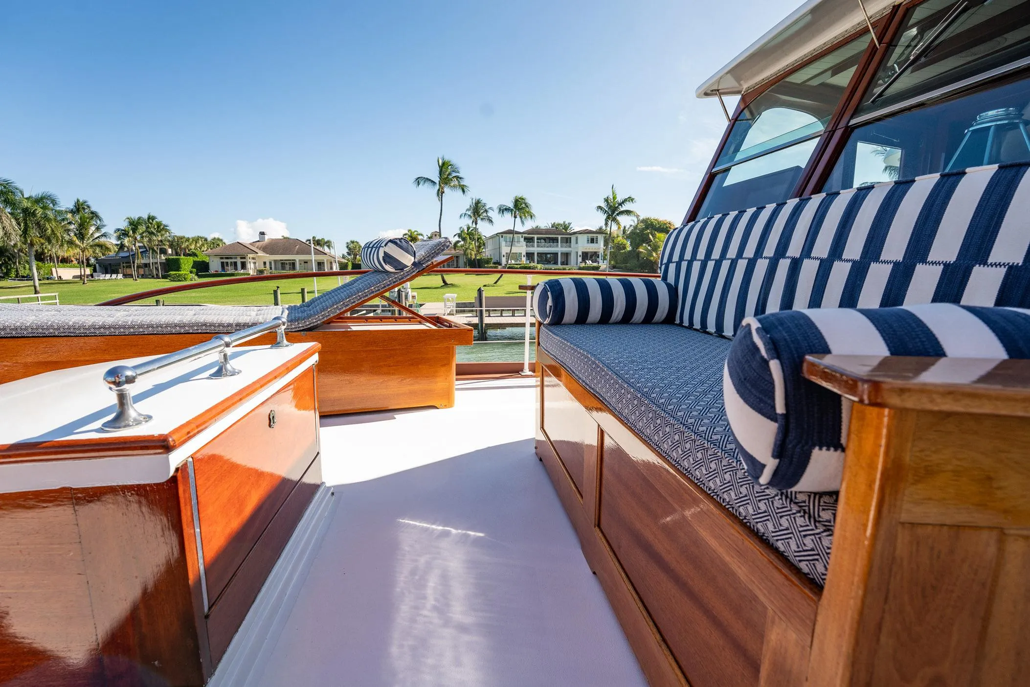 Luxurious 1937 Trumpy 58 yacht deck with striped seating and polished wood finish.