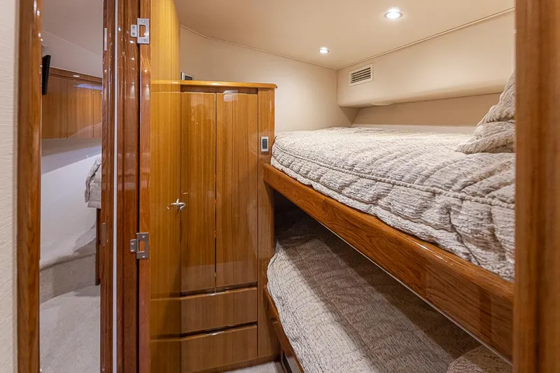 Mixer Yacht Photos Pics Interior cabin of 2015 Viking 52 yacht with wooden bunk beds and storage.
