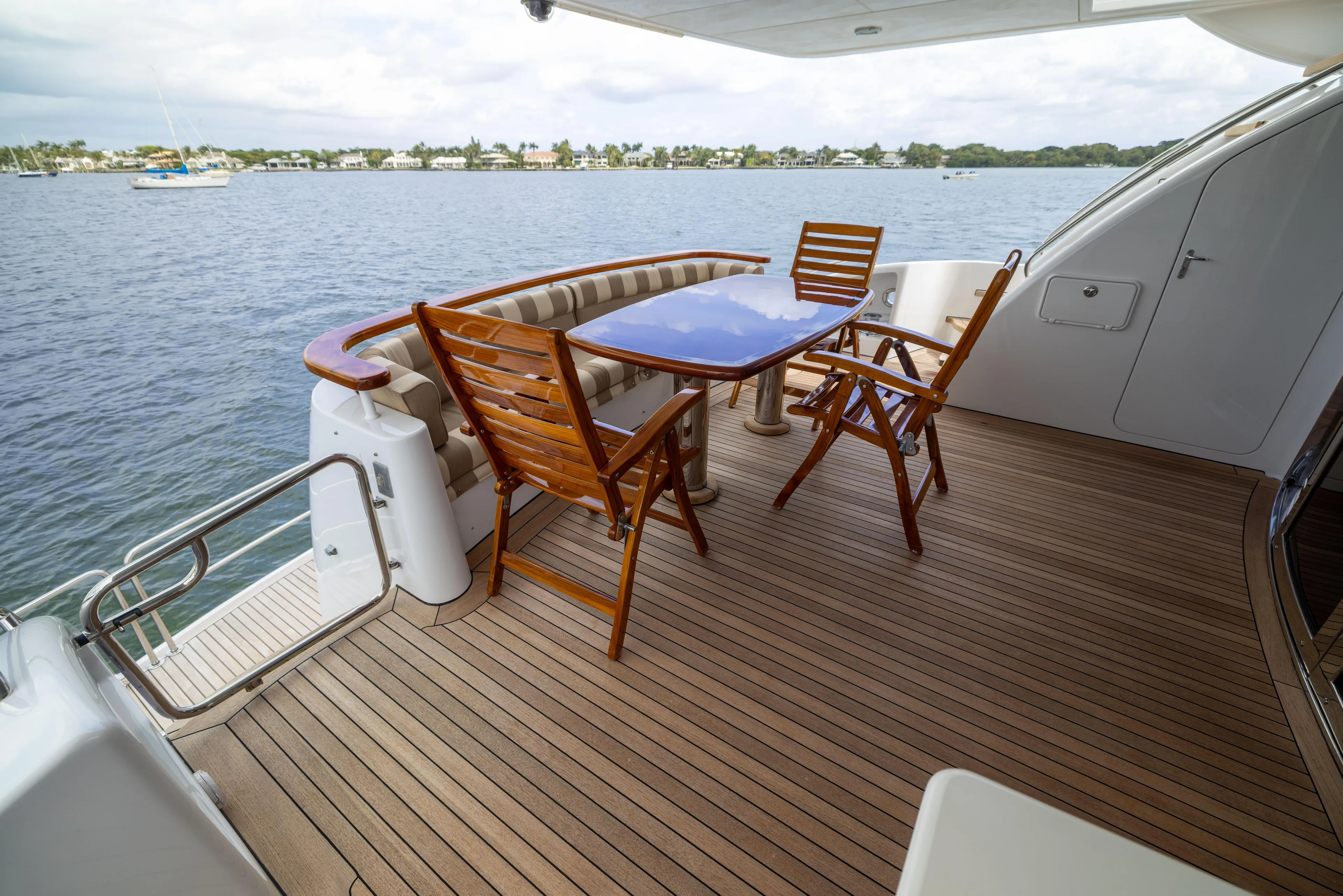 Outrageous Yacht Photos Pics Outdoor deck of 2005 Hatteras 80 Motor Yacht with wooden furniture and ocean view.