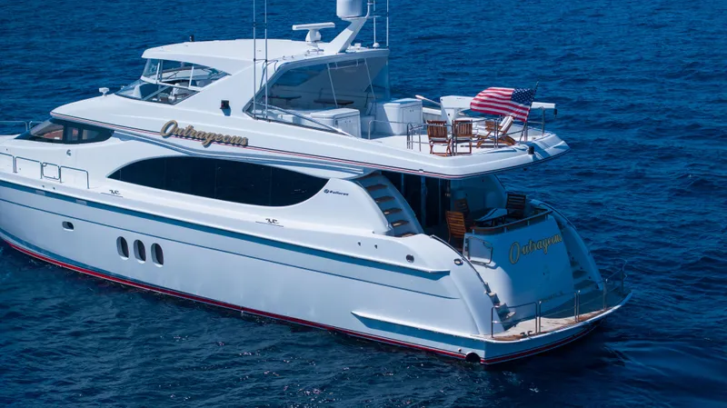 Outrageous Yacht Photos Pics 2005 Hatteras 80 Motor Yacht cruising on blue ocean waters.