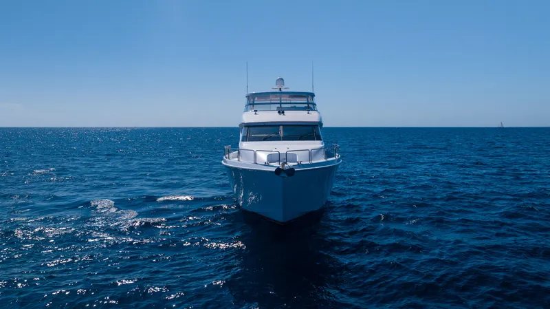 Outrageous Yacht Photos Pics 2005 Hatteras 80 Motor Yacht cruising on open sea under clear blue sky.