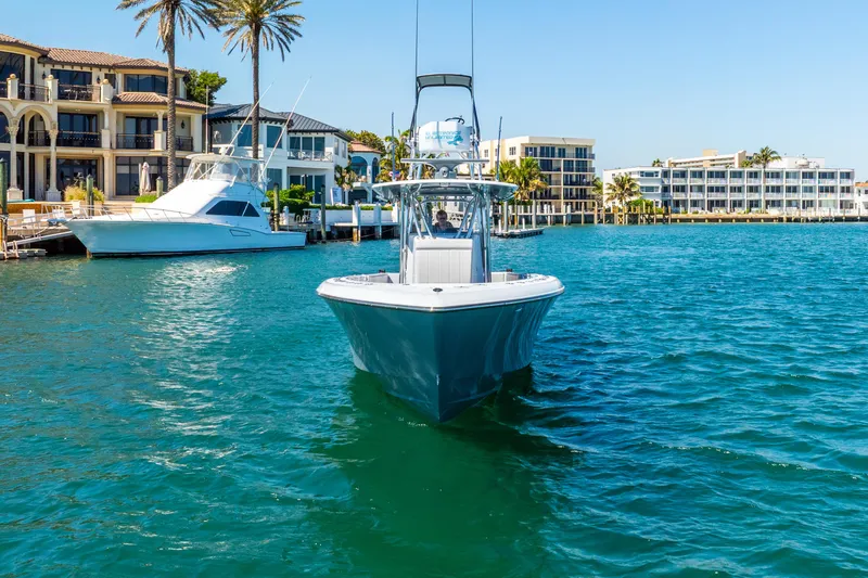  Yacht Photos Pics 2023 Contender 39ST boat cruising in a scenic waterfront area with luxury homes.