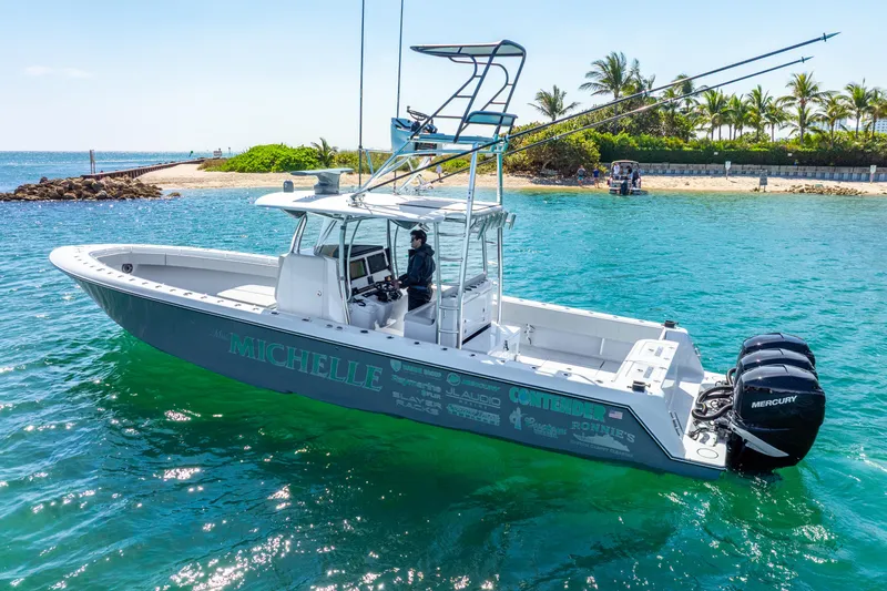  Yacht Photos Pics 2023 Contender 39ST boat on clear blue water near a tropical island.