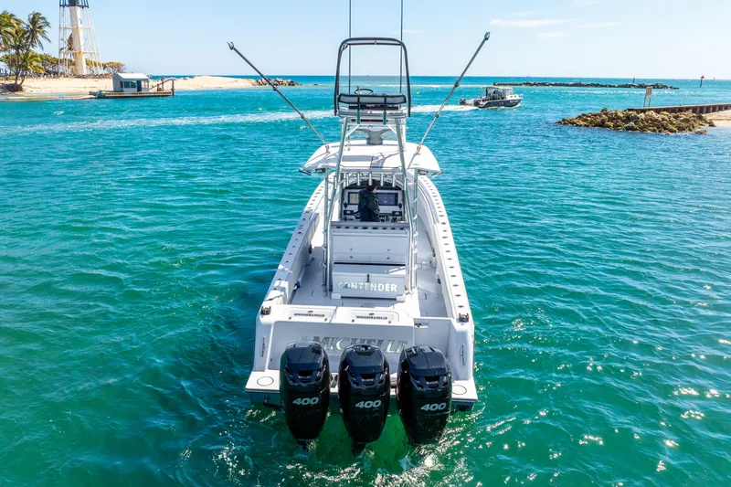  Yacht Photos Pics 2023 Contender 39ST boat with triple 400 engines on turquoise water near a sandy beach.