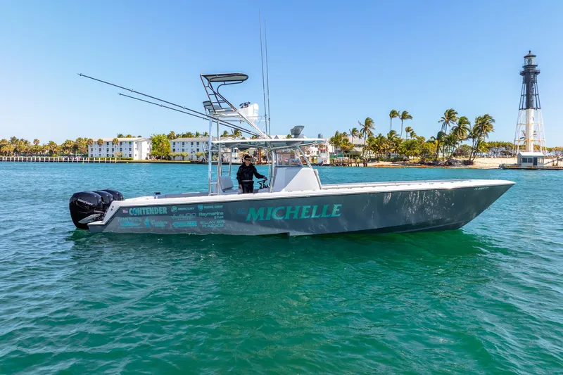  Yacht Photos Pics 2023 Contender 39ST boat named "Michelle" on water near a lighthouse and palm trees.