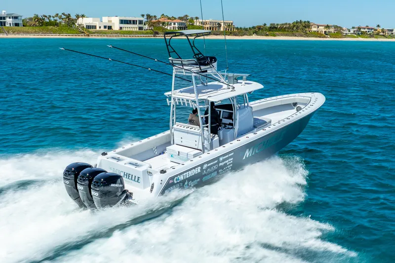  Yacht Photos Pics 2023 Contender 39ST boat cruising on blue ocean water near luxury waterfront homes.